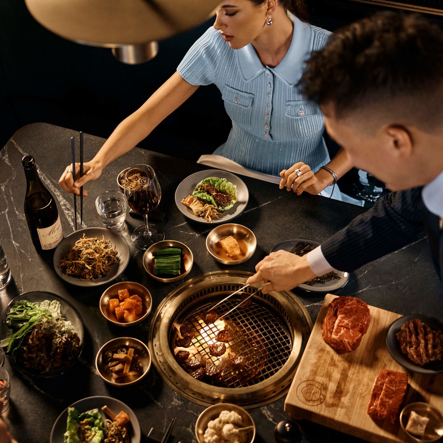 A Person And A Boy Eating At A Table Full Of Food