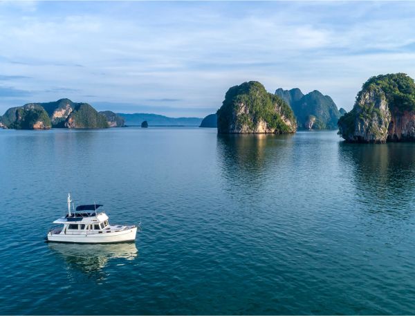 A Boat In The Water With Ha Long Bay In The Background