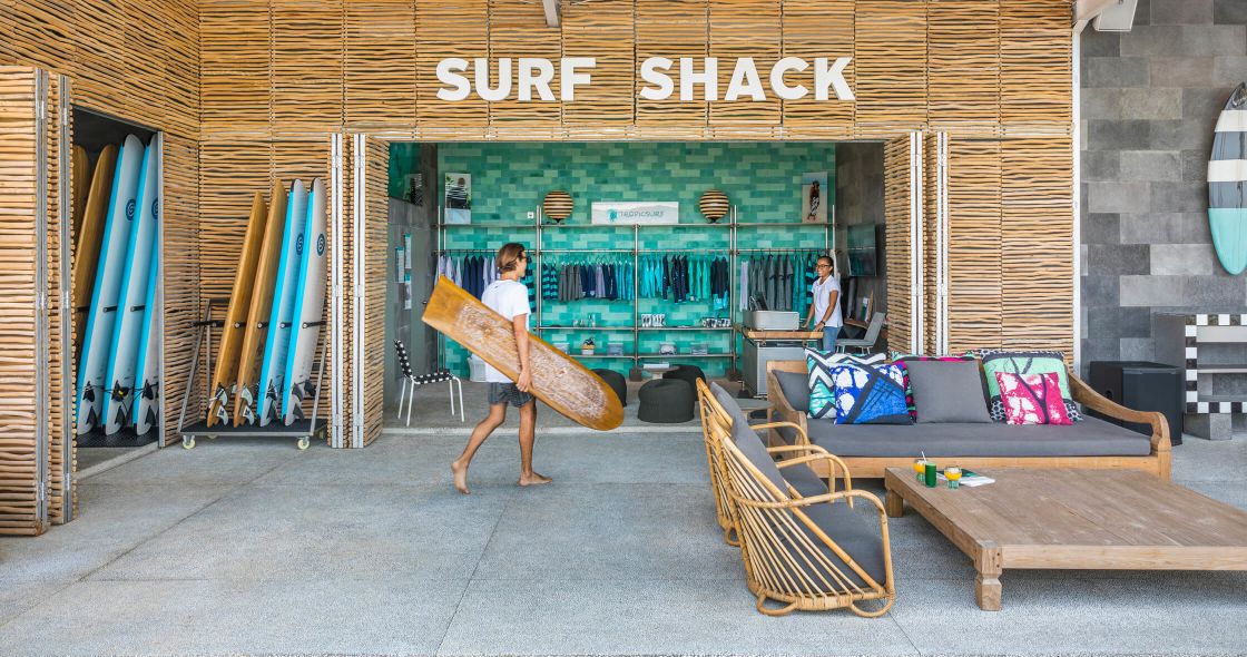 A Person Carrying A Surfboard