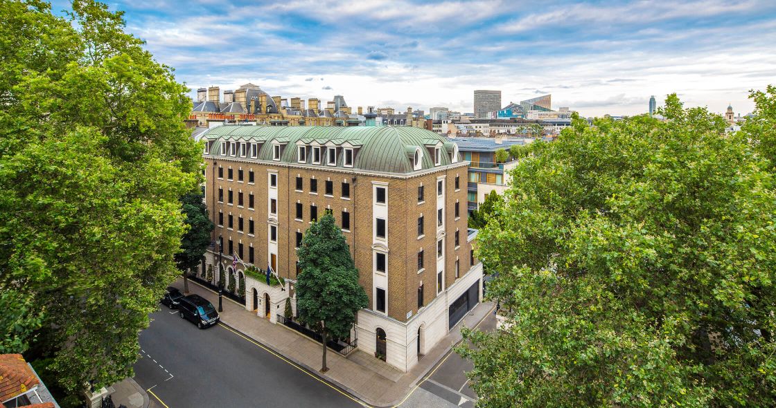 A Road With Trees And Buildings On The Side