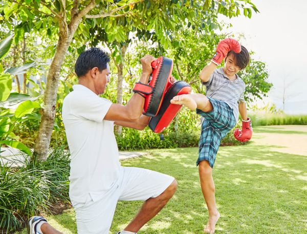A Man And A Woman Holding Red Shoes And A Child Holding A Red Bucket