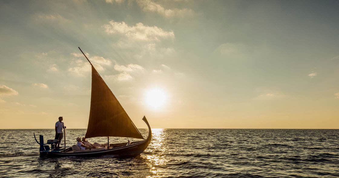 A Person On A Boat In The Water With A Sailboat