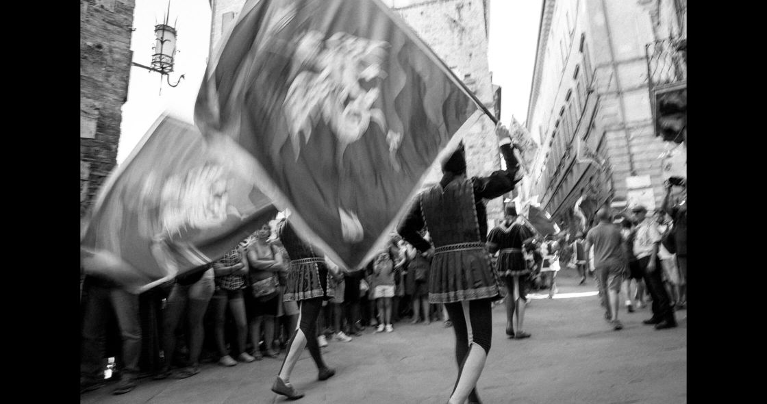 A Group Of People Walking Down A Street With A Large Balloon
