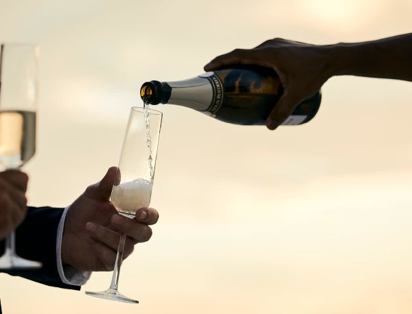 A Few People Pouring Wine Into Glasses