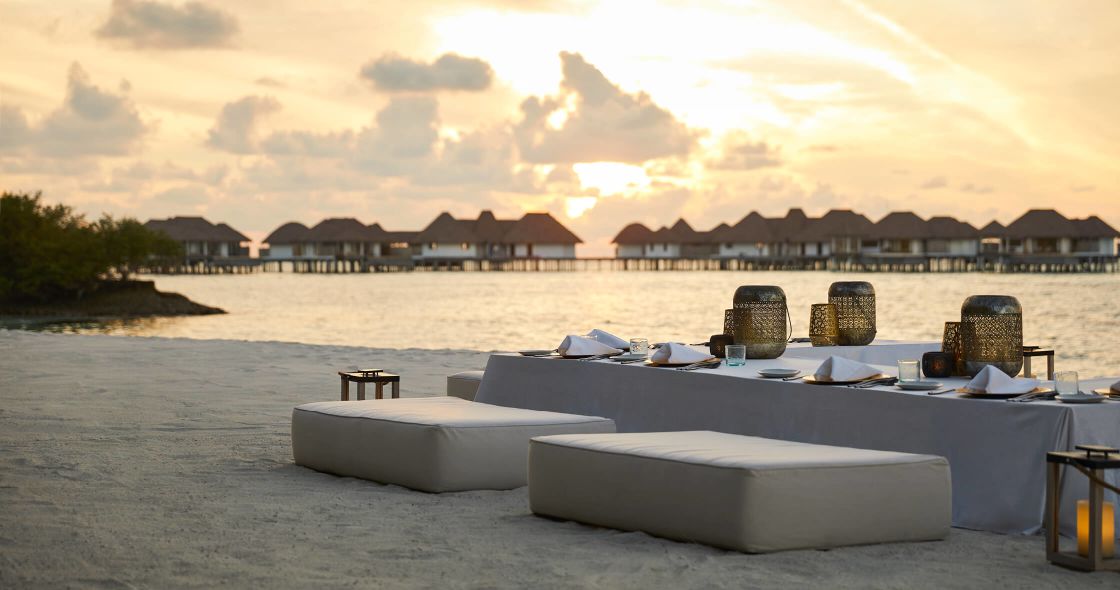 A Group Of People Sitting In Chairs In Front Of A Body Of Water