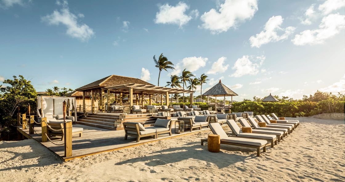 A Group Of Lounge Chairs On A Sandy Beach