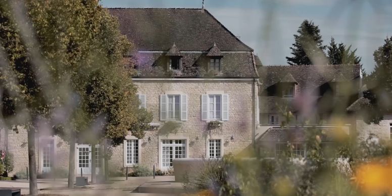 A Large House With Trees In The Front