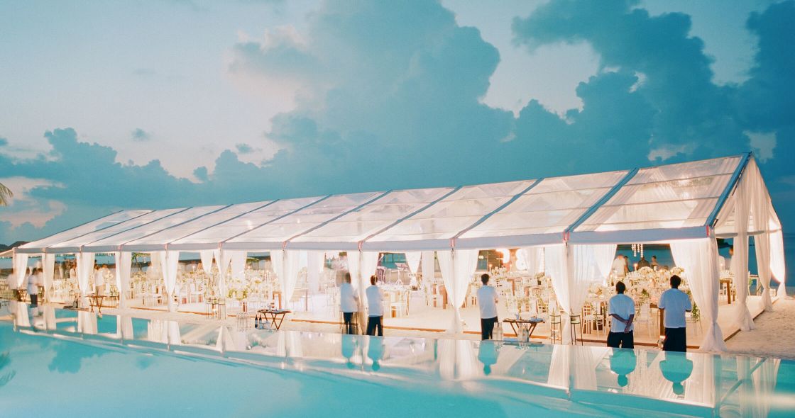 A Group Of People Standing Next To A Swimming Pool