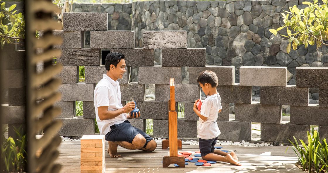 A Person And A Boy Playing With A Toy