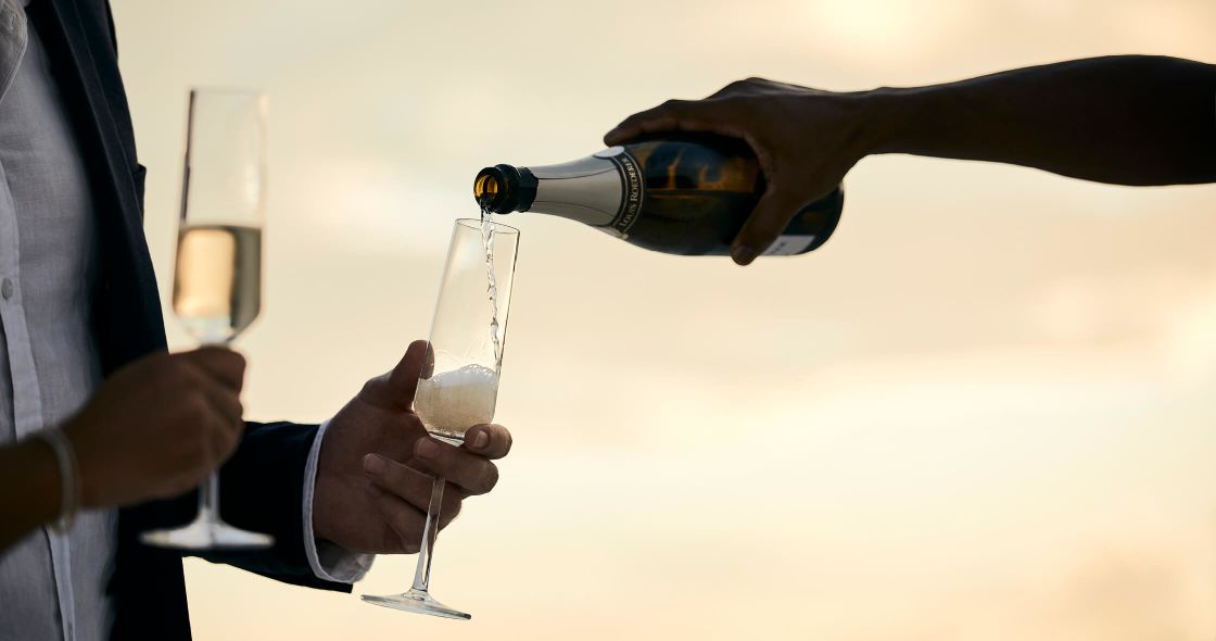 A Few People Pouring Wine Into Glasses