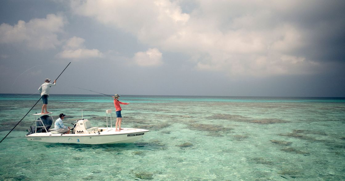 A Group Of People Fishing On A Boat In The Ocean