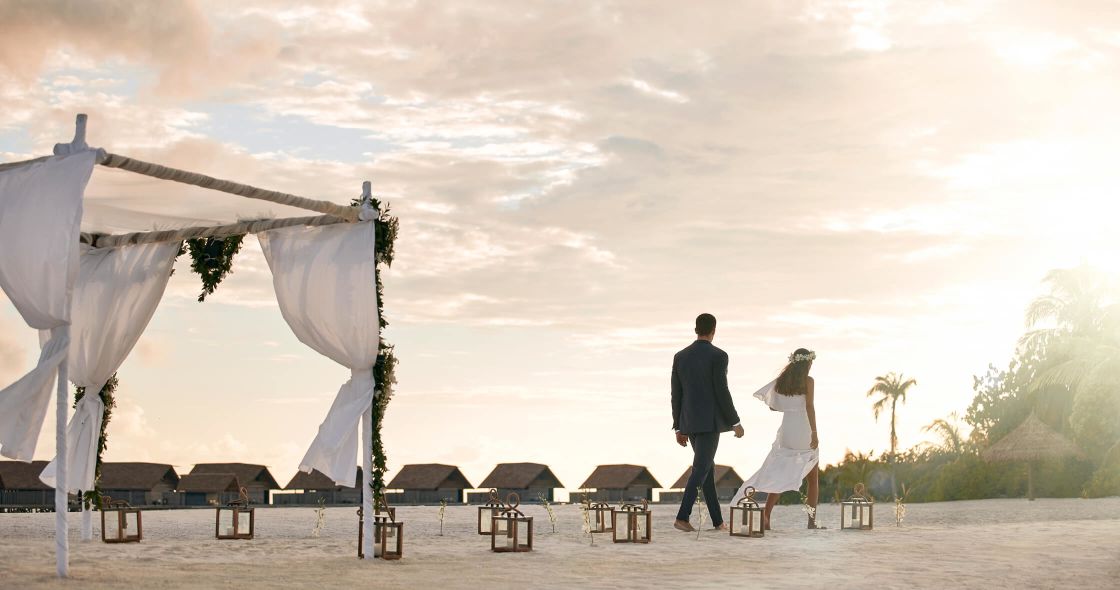 A Man And Woman Walking On A Beach