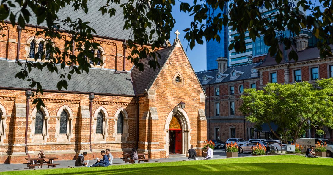 A Brick Building With A Lawn In Front Of It